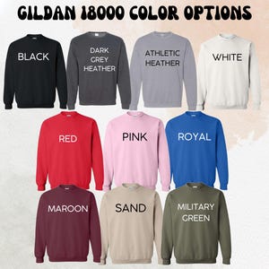 May include: A selection of Gildan 18000 sweatshirts in various colors, including black, dark grey heather, athletic heather, white, red, pink, royal, maroon, sand, and military green.