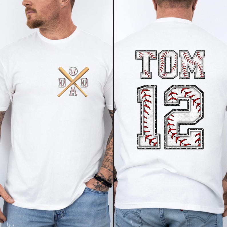 May include: White baseball t-shirt with a baseball bat and ball graphic that says "DAD" on the front. The back of the shirt has the name "TOM" and the number "12" in a baseball-themed design.