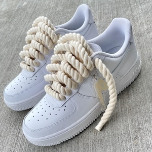 Air Force 1 personalizadas: zapatillas blancas con cordones color crema y etiqueta colgante color canela