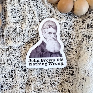 May include: Black and white sticker featuring a portrait of John Brown with the text "John Brown Did Nothing Wrong."