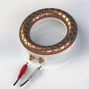 Könnte beinhalten: Ein weißes und kupferfarbenes Audiokomponente mit kreisförmigem Design. Der Kupferbereich hat ein Rautenmuster. Zwei goldfarbene Anschlüsse und zwei Audiokabel, eines rot und eines weiß, sind ebenfalls sichtbar.