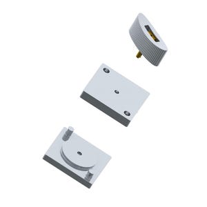 May include: Three silver-colored mechanical components are displayed against a white background. The components include a rectangular base with two holes, a square base with a circular design, and a cylindrical piece with a gold-colored center.