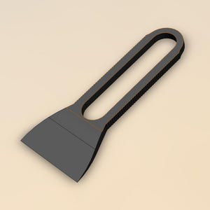 May include: A dark gray scraper tool with a rectangular blade and a handle with a central opening. The handle has a textured surface for grip. The tool is designed for scraping surfaces.