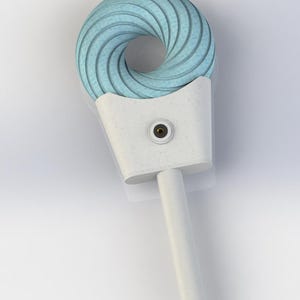 Może przedstawiać: Jasnoniebieski, spiralny obiekt z białą podstawą i uchwytem. Spirala jest teksturowana, a uchwyt cylindryczny. Mały, okrągły detal jest widoczny na białej podstawie. Obiekt jest umieszczony na białym tle.