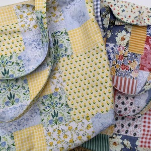 May include: Two patchwork tote bags with floral and geometric patterns. One bag features yellow gingham and floral prints, while the other showcases a mix of floral, striped, and checkered fabrics. Both bags have matching straps.