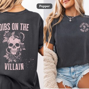 Lifestyle image of a villain lover Comfort Colors® t-shirt in pepper color. Text on the shirt says "dibs on the villain".