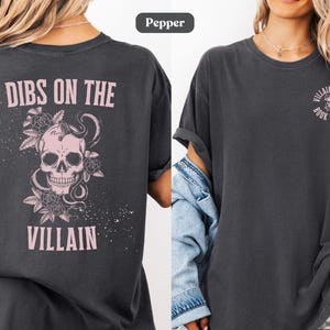 Lifestyle image of a villain lover Comfort Colors® t-shirt in pepper color. Text on the shirt says "dibs on the villain".