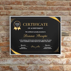 May include: A black and gold certificate of achievement with a gold ribbon and stars. The certificate is presented to Donna Stroupe for her achievements. The text reads "The Best Awards" and "Certificate of Achievement".