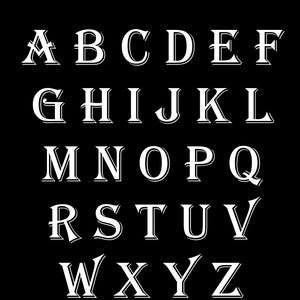May include: A black background displays the alphabet in white, vintage-style lettering. The letters are arranged in rows, with the text "#5 Vintage Stock" at the top. The font has a classic, elegant appearance.