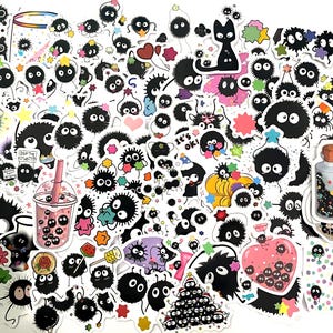 May include: A collection of numerous die-cut stickers featuring black soot sprites with large white eyes. The designs include sprites with colorful stars, hearts, flowers, a black cat, a bubble tea cup, a glass bottle, and text reading it's ok.