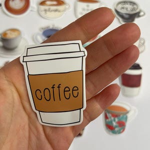May include: A white to-go coffee cup with a brown lid and the word "coffee" printed on the side.