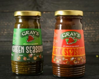 May include: Two glass bottles of Gray's all natural seasoning. The bottle on the left is green and labeled "Green Seasoning". The bottle on the right is brown and labeled "Jerk Seasoning".