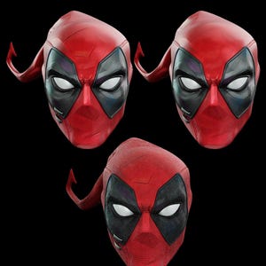 May include: Three red and black Deadpool masks are displayed against a black background. The masks have white eye shapes, black eye surrounds, and a red textured surface. The masks are a comic book and movie-themed item.