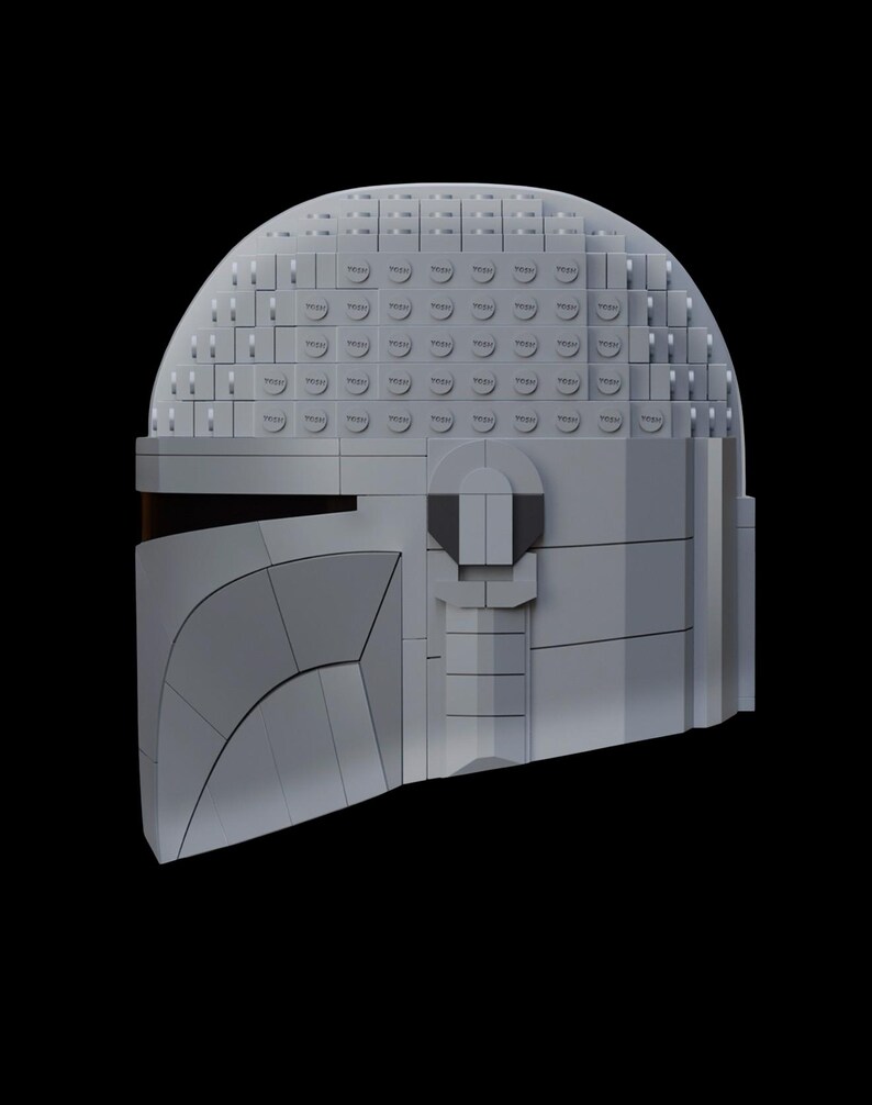 May include: A gray Mandalorian helmet constructed from interlocking toy bricks. The helmet features a curved visor and a segmented design, with a dark visor area. The helmet is set against a black background.
