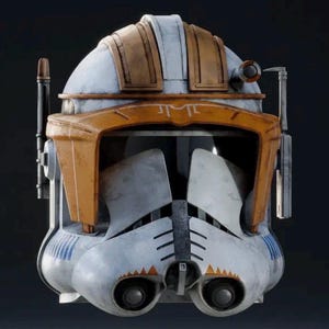 May include: A detailed, weathered helmet with a white, orange, and brown color scheme. The helmet features a visor, ear pieces, and various mechanical details. The design is reminiscent of a science fiction or military aesthetic.