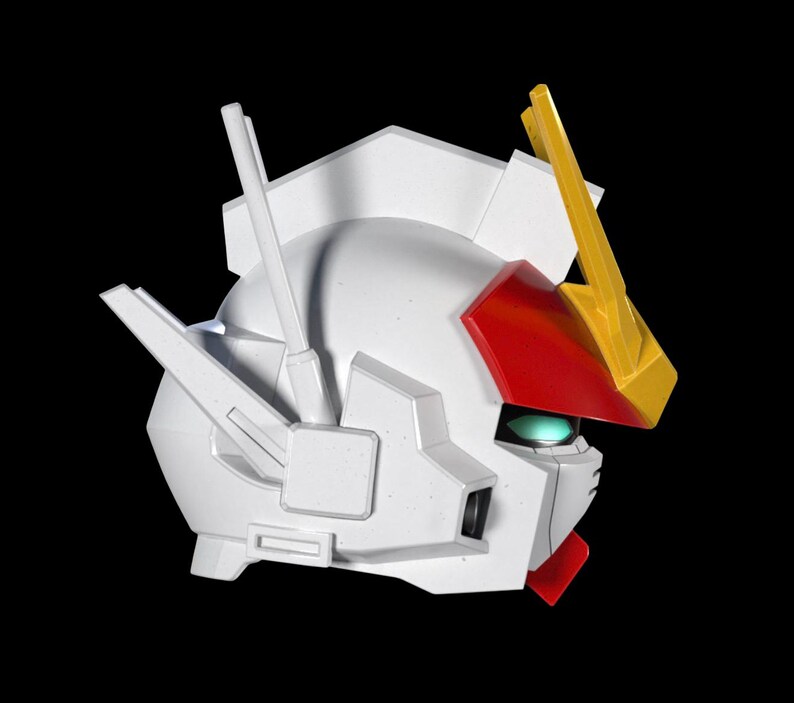 May include: A white robot head with red, yellow, and green accents. The head has a detailed design with angular features and a prominent crest. The robot head is set against a black background.