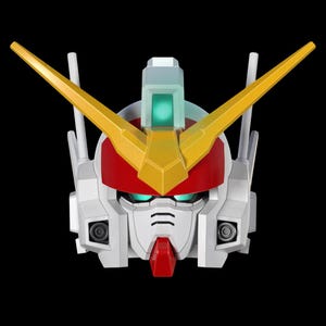 May include: A close-up of a Gundam robot head, featuring a white face with red and yellow accents. The robot has a red helmet, yellow V-fins, and green eyes. The background is solid black.