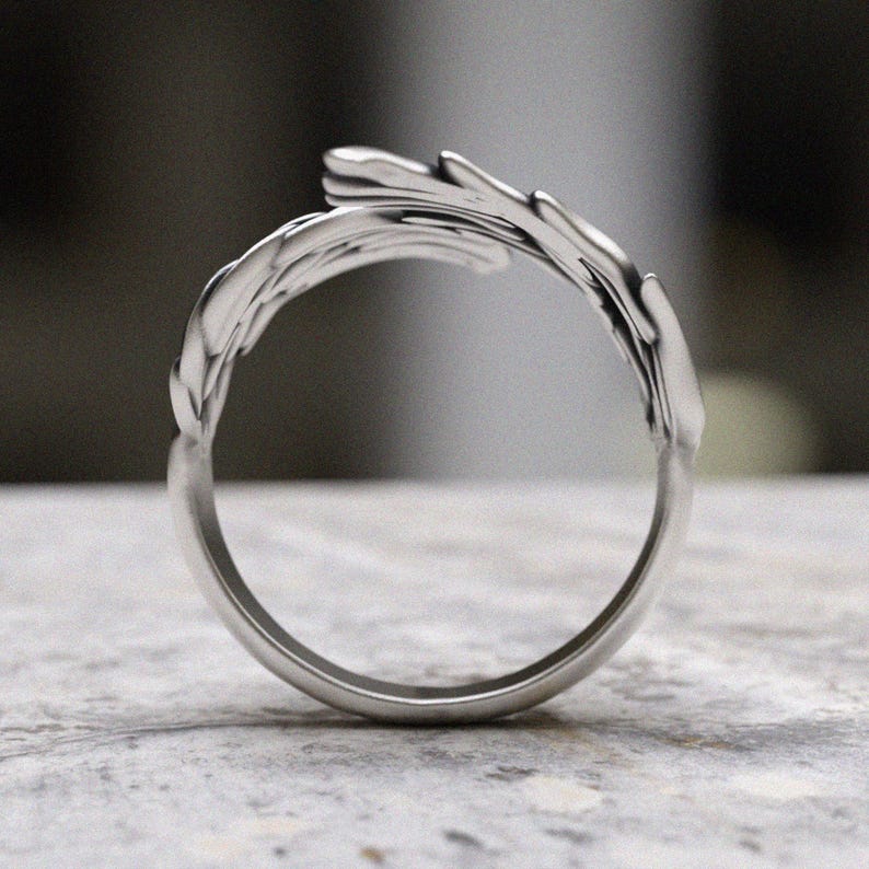 Sterling silver statement ring with detailed angel wing design wrapping around the finger