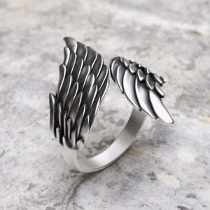 Angel wing wrap ring in sterling silver showing intricate layered feather pattern from side angle