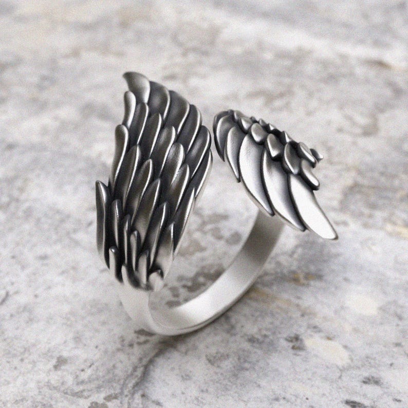 Angel wing wrap ring in sterling silver showing intricate layered feather pattern from side angle