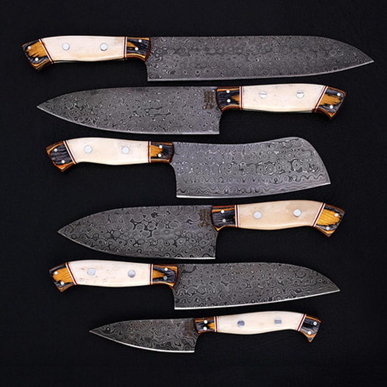 Custom Handmade Damascus Steel Chef Knife Set, crafted for top-tier kitchen performance. Each knife boasts a stunning wave pattern on the blade, paired with an ergonomic bone handle for comfort and control. This set is perfect for culinary professionals, BBQ enthusiasts, and home chefs who value quality and craftsmanship. A great personalized gift for groomsmen, anniversaries, or special occasions.