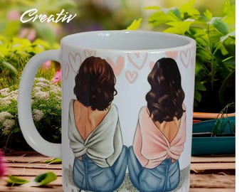 May include: White ceramic mug with a design of two women with brown hair wearing sweaters and jeans. The mug has pink hearts and the names "Lucia" and "Belen" written on the bottom.
