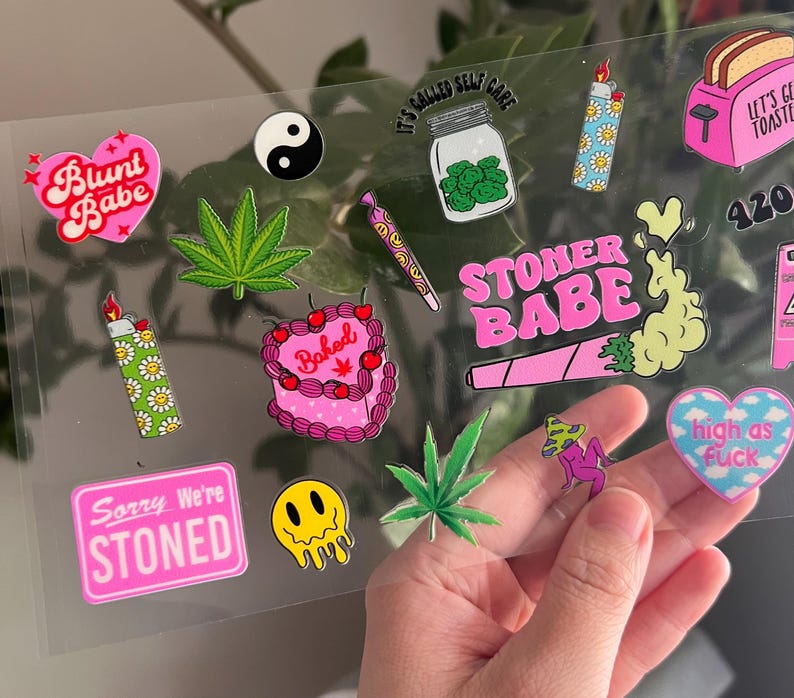 Może przedstawiać: Arkusz r&oacute;żowych i zielonych naklejek z r&oacute;żnymi wzorami, w tym blunt, joint, upieczony tort, zapalniczka, liść i tekst "Blunt Babe", "Stoner Babe", "Sorry We're Stoned", "It's Called Self Care", "420" i "High as Fuck".