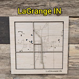 May include: A wooden map of LaGrange, IN, with a detailed street layout. The map is laser-cut and framed, featuring the text "LaGrange IN" at the top and bottom. The background is a rustic wooden surface.