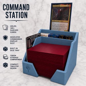 Op de afbeelding: Een lichtblauw plastic commandostation voor ruilkaarten. Het beschikt over een verticale sleuf voor een commander-kaart, een centraal compartiment met een stapel kaarten in rode hoesjes en een achterste vak met diverse gekleurde dobbelstenen.