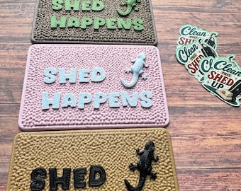 May include: Four rectangular textured mats featuring the text SHED HAPPENS and a lizard figure in black, brown, pink, and tan. To the right, three circular stickers display the text CLEAN THIS SHED UP with a vacuum cleaner illustration.