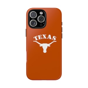 May include: Orange phone case with a white "TEXAS" logo and longhorn graphic. The case has a glossy finish and a camera cutout with three lenses.