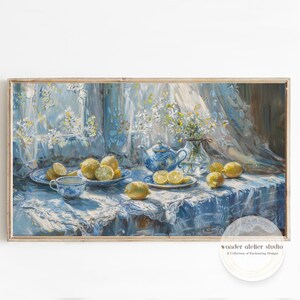 Könnte beinhalten: Gerahmtes Stillleben-Gemälde mit Zitronen, einer Teekanne und Tassen auf einer blauen Tischdecke. Das Kunstwerk hat eine Vintage-Ästhetik mit weicher Beleuchtung und einem Blumenarrangement in einer Vase. Das Gemälde ist in einem Holzrahmen.