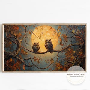 Könnte beinhalten: Gerahmtes Gemälde mit zwei Eulen auf einem Ast vor einem Vollmond. Das Kunstwerk verwendet eine warme Farbpalette mit Braun-, Orange- und Blautönen und schafft eine ruhige, nächtliche Szene. Natur-Themen-Kunstwerk.