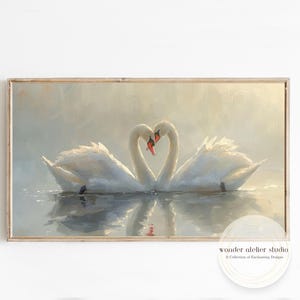 Könnte beinhalten: Gerahmtes Kunstwerk mit zwei weißen Schwänen, deren Hälse ein Herz bilden. Die Schwäne befinden sich in einer ruhigen Wasserumgebung mit sanften, gedämpften Farben. Das Kunstwerk hat eine Vintage-Ästhetik.