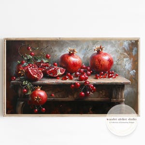 Peut inclure: Peinture de nature morte encadrée avec des grenades et des baies rouges sur une table en bois. Les grenades sont entières et tranchées, avec des graines visibles. L'œuvre d'art a une palette de couleurs chaudes et une esthétique vintage.