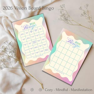 May include: Two vision board bingo cards with a pastel rainbow design. The cards have a cream background with a colorful border. One card is filled with prompts, and the other is blank. The text "2026 Vision Board Bingo" is at the top.