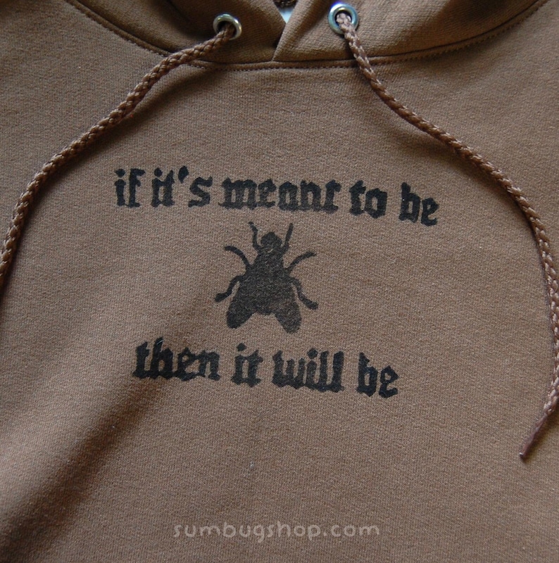 May include: Brown hoodie with a drawstring and a graphic of a fly and the text "if it's meant to be then it will be". The hoodie has a hood and a drawstring.