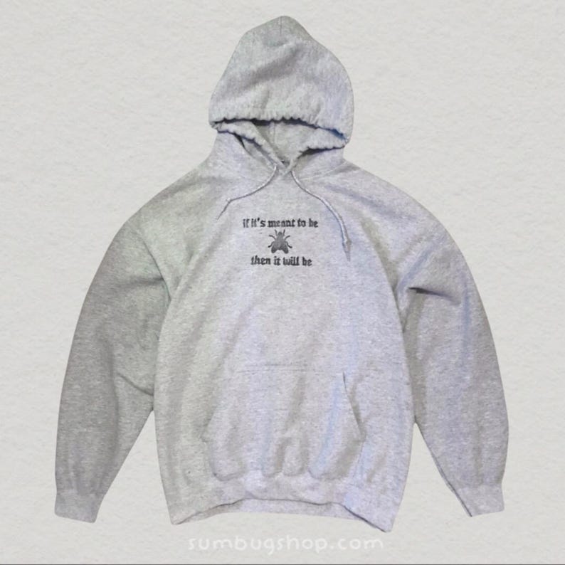 May include: A heather gray hoodie with a drawstring hood and a front pocket. The hoodie features the embroidered text "if it's meant to be then it will be" above a small insect graphic. The website "sumbugshop.com" is printed at the bottom.