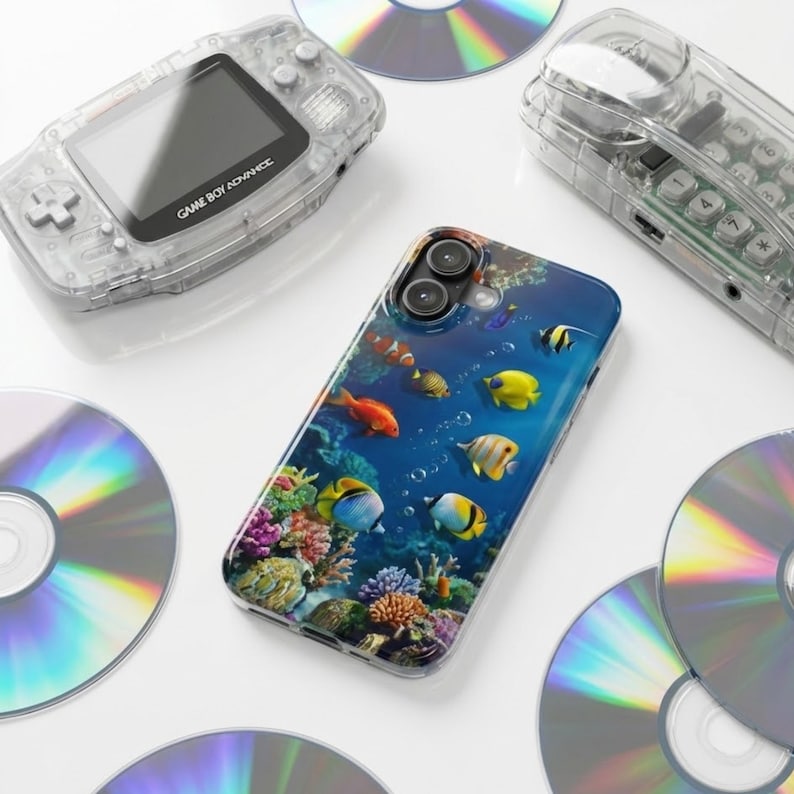 Pode incluir: Uma capa de telefone transparente com uma vibrante cena subaqu&aacute;tica com peixes e corais coloridos. Um Game Boy Advance transparente e um telefone fixo transparente tamb&eacute;m s&atilde;o vis&iacute;veis, juntamente com v&aacute;rios CDs. A capa do telefone tem um acabamento brilhante.