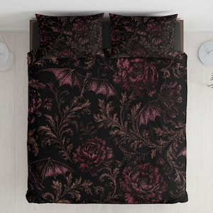 Könnte beinhalten: Schwarzes Bettwäsche-Set mit einem gotischen Blumen- und Fledermaus-Design. Der Bettbezug und die beiden Kissenbezüge haben einen dunklen Hintergrund mit burgunderfarbenen Rosen, braunem Laub und Fledermaus-Silhouetten.
