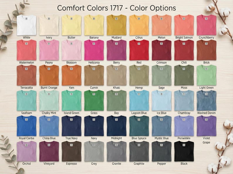 May include: A color chart of Comfort Colors 1717 t-shirts, showcasing a wide array of hues. The image displays a grid of various colors, including white, ivory, yellow, pink, red, blue, and green. Each shirt is neatly folded, with the color name displayed below.