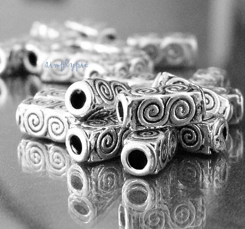 Peut inclure: Perles en m&eacute;tal argent&eacute; avec un motif en spirale. Les perles sont empil&eacute;es les unes sur les autres et ont un trou au centre.