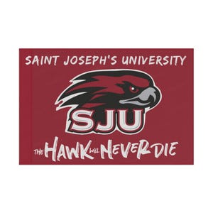 May include: A red and white Saint Joseph's University flag with a hawk logo and the text "SJU" and "The Hawk Will Never Die".