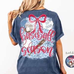 Op de afbeelding: Marineblauw T-shirt met een honkbalthema. Het ontwerp bevat een rode strik, honkbal, knuppel en de woorden "Baseball Season". De achtergrond heeft een blauwe luipaardprint.