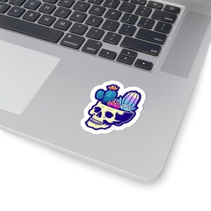 Pode incluir: Um adesivo com uma ilustração colorida de uma caveira com uma variedade de cactos crescendo no topo de sua cabeça.