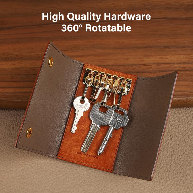 May include: A brown leather key holder with gold hardware, holding several keys. The key holder is open, revealing the keys and the interior design. The text "High Quality Hardware 360&deg; Rotatable" is visible at the top.