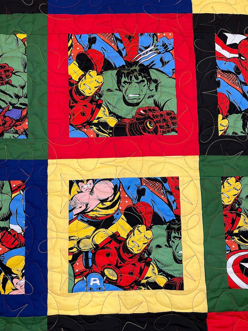 K&ouml;nnte beinhalten: Eine bunte Quiltdecke mit Patchwork-Muster, die verschiedene Marvel-Superhelden zeigt, darunter Iron Man, Hulk, Wolverine, Spider-Man und Captain America. Die Decke ist aus verschiedenen Stoffen in unterschiedlichen Farben gefertigt und hat ein gestepptes Muster.