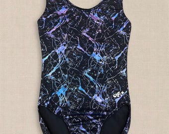 May include: A sleeveless leotard featuring a black base with a vibrant, multi-coloured marble-like pattern in shades of blue, purple, and white. The garment has a scoop neckline and a small white logo with the letter A and a star on the lower right.