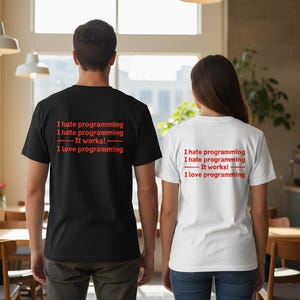 May include: Black and white t-shirts with the text "I hate programming, It works!, I love programming" in red. The shirts are worn by two people, viewed from the back. The setting appears to be indoors, with a warm, inviting atmosphere.
