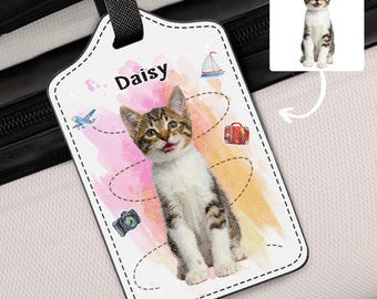 May include: White luggage tag featuring a tabby cat named Daisy. The tag includes travel-themed illustrations like a plane, suitcase, camera, and sailboat. A small image of the cat is in the upper right corner.